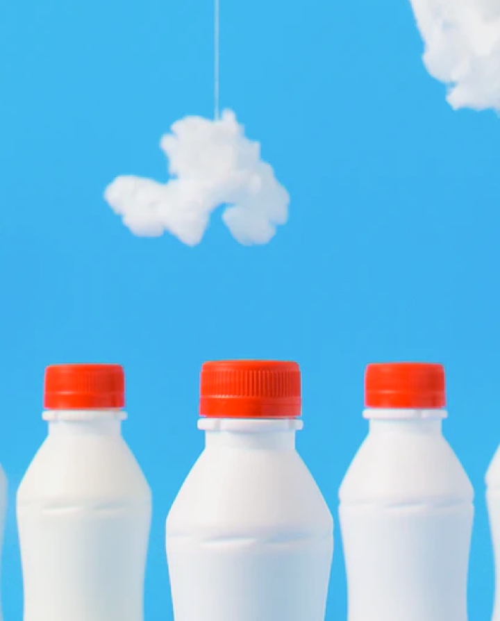 milkbottles with red lids on blue background with clouds